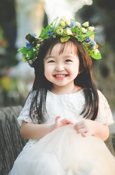 Foto eines hübschen lächelnden Mädchens, das einen Kranz trägt