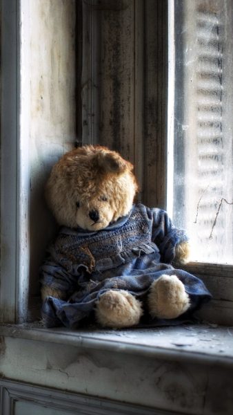 Hình ảnh gấu bông buồn ngồi bên cửa sổ