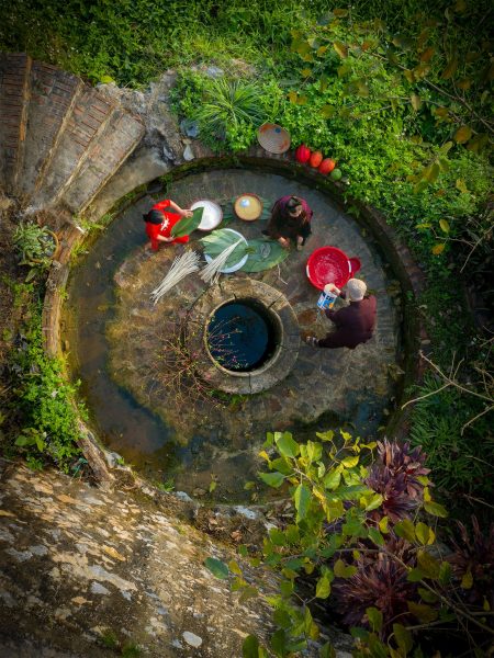 Bilder von vietnamesischen Dörfern, die Kuchen an einem Brunnen verpacken