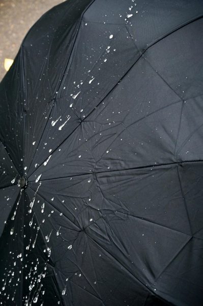 Bild eines Wassertropfens auf einem schwarzen Regenschirm
